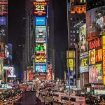 Times Square iluminado por anuncios publicitarios tradicionales y pantallas digitales.