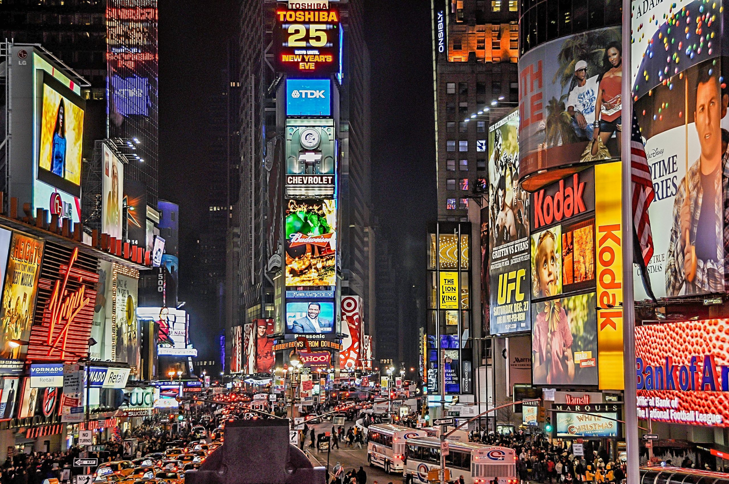 Times Square iluminado por anuncios publicitarios tradicionales y pantallas digitales.