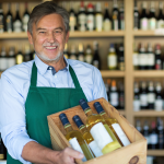 Botellas de vino en una caja que lleva un vendedor, lista para entregar al repartidor.